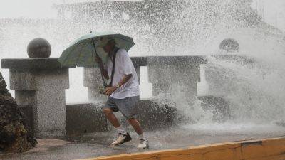 Typhoon bringing heavy rain slowly heads toward Taiwan, where 4,000 have evacuated