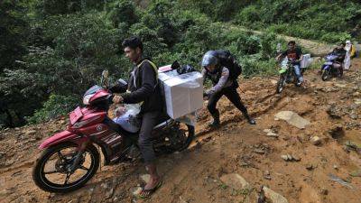Election ballots and boxes carried across Indonesia by motorcycle, boat, horse and on foot