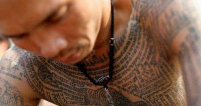 Thousands, some in trance, pay homage to sacred Thai tattoo master