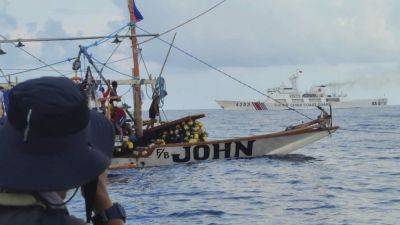 Filipino activists decide not to sail closer to disputed shoal, avoiding clash with Chinese ships