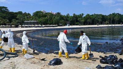 Singapore races to clean oil spill as luxury beach resort coated in slick