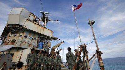 Chinese state media says Philippine troops pointed guns at coastguards near disputed South China Sea reef