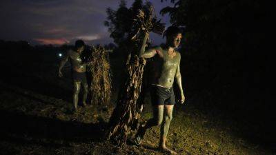 Philippine villagers smear mud on their bodies to show devotion to St. John the Baptist