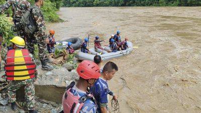Rescuers in Nepal search for 2 buses with more than 50 people on board that was swept into a river