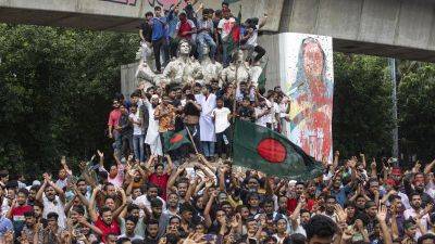 Bangladesh prime minister flees to India as anti-government protesters storm her residence