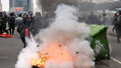 Tear gas, stun grenades and manure let fly at Australia military expo protests