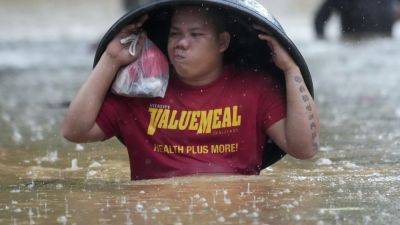 Fierce storm blows out of northern Philippines after leaving 14 dead in landslides and floods